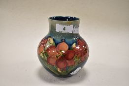 A mid century Moorcroft pottery vase having tube lined lily design in russet on blue ground.