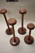 Four vintage mahogany wig stands.