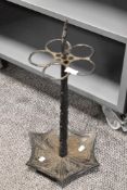 An ornate antique cast metal stick/ umbrella stand with integrated drip tray.