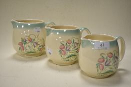 Three graduated Susie Cooper 'Dresden' jugs having cream ground with floral spray design, pattern no
