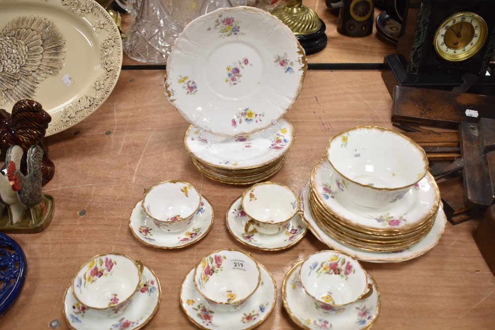 A late 19th century partial tea service, having hand tinted floral decoration and gilt accents,