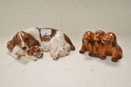 A Royal Doulton dog and puppy study, and A Beswick trio of dogs.