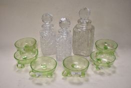 Six Art Deco green glass fruit bowls having etched design, and three cut glass decanters, AF.