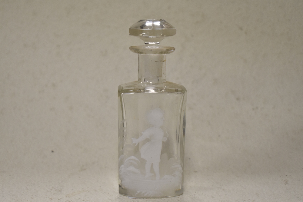 A 20th century clear glass perfume bottle having faceted stopper and white enamel decoration in