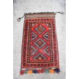 A vintage saddlebag rug, having traditional pattern in red, blue, green, orange and cream.