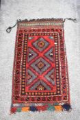 A vintage saddlebag rug, having traditional pattern in red, blue, green, orange and cream.
