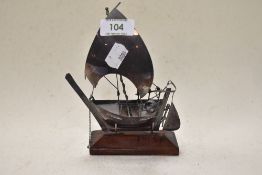 A 20th century white metal model sailing boat on wooden stand, tested as silver.