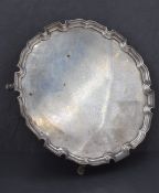 A George V silver salver, of circular form with moulded 'Chippendale' rim, raised on four short legs