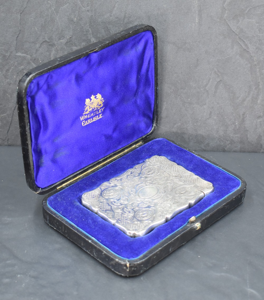 A Victorian silver visiting card case, of shaped and hinged rectangular form, engraved throughout