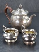 A matched George V silver three piece teaset, comprising teapot, sugar and cream, the teapot of
