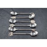 A group of six Eastern white metal spoons, each having twisted stems and differing terminals,