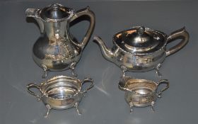 An Edwardian silver four-piece teaset, of oblong baluster form with moulded edge detail and scrolled