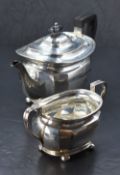 A George V silver two-piece teaset, comprising teapot and sugar, of oval form with fluted detail,