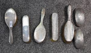 A selection of mixed silver mounted dressing table brush sets, various designs, makers and age, some