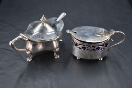 A George V silver mustard, of lobed oval form with hinged cover over the Bristol blue glass liner,