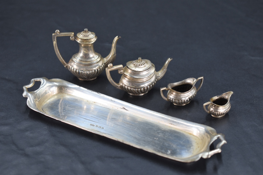 A miniature five-piece silver teaset, of half gadrooned oval baluster form, comprising teapot,