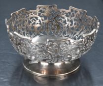 A George V silver bowl, of dished circular form with castellated rim over attractive foliate