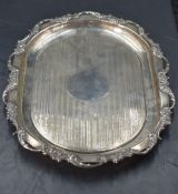 An Edwardian silver tray, of rounded rectangular form, having a foliate scroll moulded rim enclosing