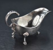 An Edwardian silver gravy boat, of generous proportions with scrolled-over handle and three down