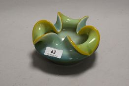 A mid century opaque glass ash tray having a heavy set blue green and yellow body.