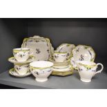 An early 20th century Paragon part tea service in a yellow floral print with bird of paradise