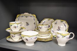 An early 20th century Paragon part tea service in a yellow floral print with bird of paradise