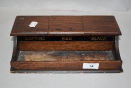 An Edwardian desk top ink well in oak having compartments for Red, Black and Blue.