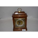 A modern John Walker Elliott bracket clock having a Walnut burr veneer case.