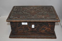 An antique sewing case or jewellery box having a naturalistic carved and poker worked case