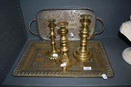 Three brass candlesticks with a brass Indian tray decorated with elephant scenes.