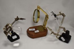 Three adjustable magnifying glasses on stands