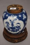 An antique Chinese export ginger jar having both carved lid and stand decorated with two panels of