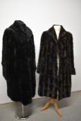 A 1930s black fur coat with shawl collar and wide cuffs and a 1940s fur coat in brown.