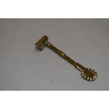 An antique brass pastry jigger having a heart shape cutter handle.