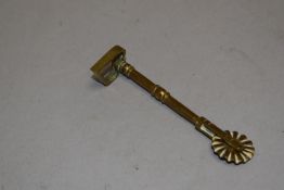 An antique brass pastry jigger having a heart shape cutter handle.