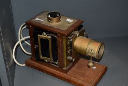 A late Victorian magic lantern slide projector having a brass and oak case having later been adapted