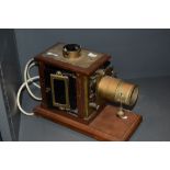 A late Victorian magic lantern slide projector having a brass and oak case having later been adapted