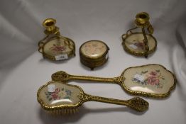 An vintage dressing table set in brass with embroidery backed handles.