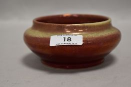 An early 20th century Royal Lancastrian pottery bowl having a red ground and yellow lustre glaze,