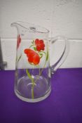 A large water jug with hand painted poppy decoration.