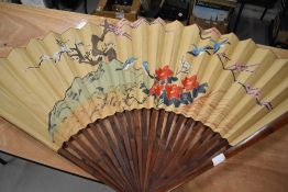 A large size Japanese fan being hand decorated with fantasy landscape.