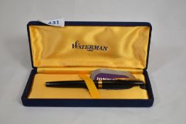 A boxed Waterman CF converter filler fountain pen in black with gold trim having 18ct nib, in