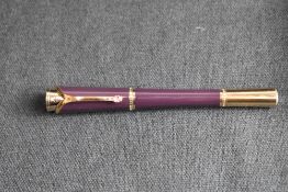 A Montblanc Princess Grace of Monaco roller ball pen. In royal purple and gold trim with pink