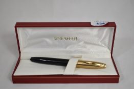 A boxed Sheaffer Legacy Mk1 piston fill in black with brushed gold cap having Sheaffer 18k nib. In