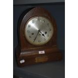 A 1920s oak chiming mantel clock, having plaque to foot reading 'Presented to Mr W H Green, by his