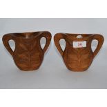 A pair of carved wood handled vases, having floral decoration.