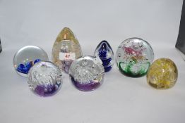 Seven glass paperweights, various shapes and colours, AF, one chipped.