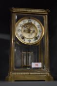 An early 20th century brass and glass cased mantel clock, having enamel face, bevelled glass doors