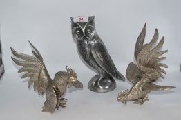 Two cast white metal cockerel studies and a similar owl.