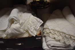 A box of vintage and retro table linen, bed throws, net curtains etc.